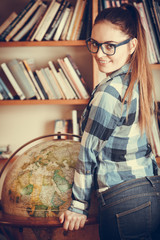 Wall Mural - Hipster girl in library working with globe