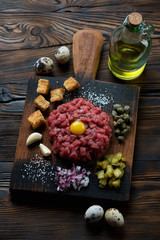 Wall Mural - Rustic wooden cutting board with beef steak tartare, studio shot