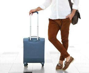 Man holding suitcase on light background