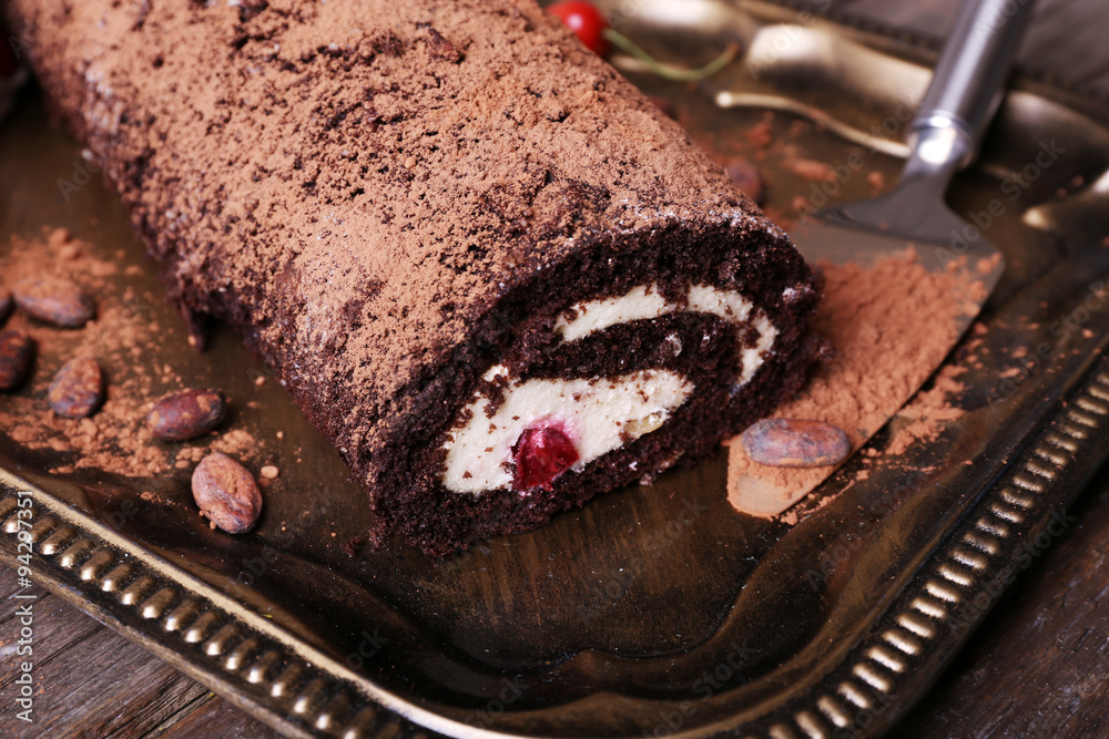 Chocolate roll with cream and berries on table close up