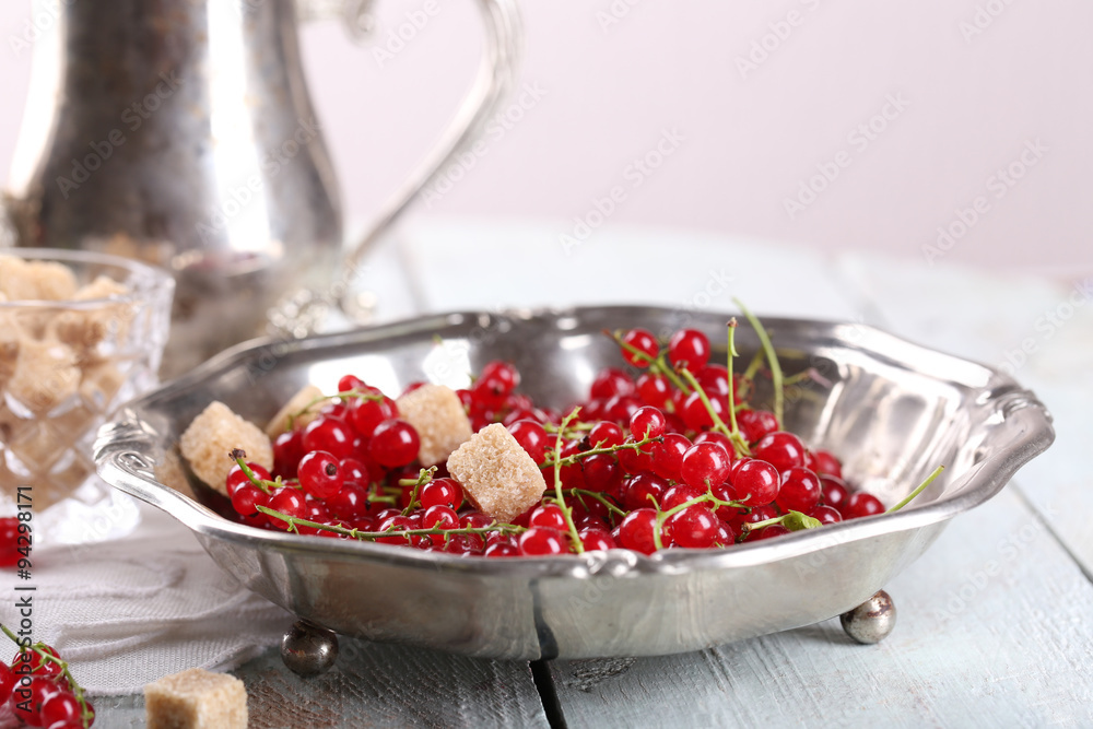 Fresh red currants with sugar on table close up