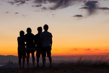 Four People Silhouettes On Top Of Hill During Sunset