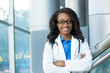 © ashtproductions - Closeup portrait of friendly, smiling confident female healthcare professional with lab coat, stethoscope, arms crossed. Isolated hospital clinic background. Time for an office visit
