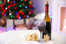 Bottle And Glass Of Wine With Christmas Decor Against Colorful Bokeh Lights Background