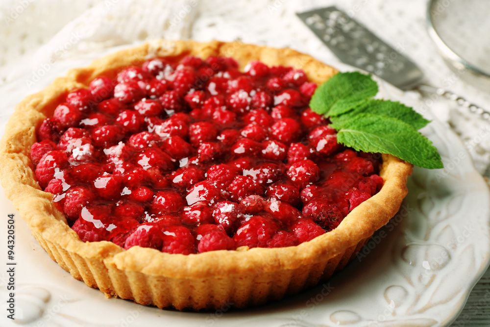 Tart with raspberries, on wooden background