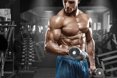 miesniowy-mezczyzna-pracujacy-w-gym-robi-cwiczeniom-z-dumbbells-przy-bicepsami