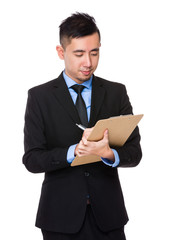 Canvas Print - Young Businessman take note on clipboard