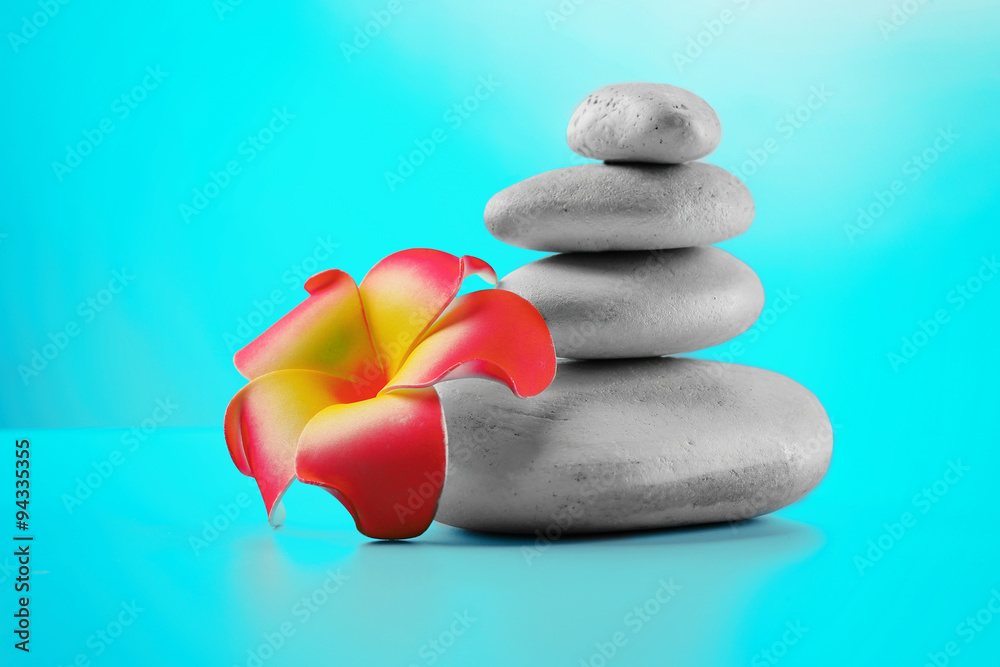 Spa stones and flower on blue background