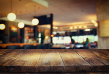 Image Of Wooden Table In Front Of Abstract Blurred Background Of Restaurant Lights
