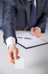 Man's hand reaching out a business card