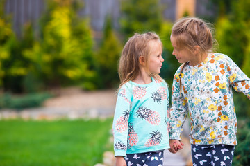 Wall Mural - Little adorable girls walking at warm sunny autumn day