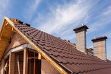 Fototapeta Konie - View on the tiled roof with chimneys from second floor of a new house