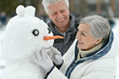 © aletia2011 - Happy senior couple with snowman