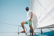 © SFIO CRACHO - Low angle view of young bearded man standing on the yacht