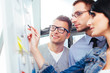 © baranq - Colleagues discussing their results in front of a board