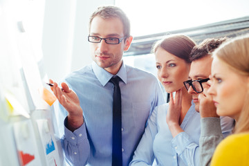 Poster - Sales representatives in a meeting with their manager and comparing their sales