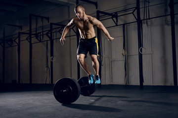 Wall Mural - Men jumping over barbells