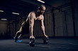 © baranq - Athlete making push ups on kettlebells for better strength