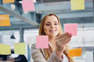 Wall Mural - Happy designer sticking notes on window at office