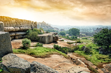 Fototapete - Ancient ruins of Vijayanagara Empire in Hampi at sunset sky, Karnataka, India.