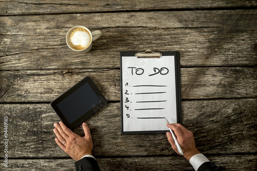 Top view of male hand writing a To do list on a white sheet of p Poster