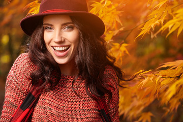 Poster - Elegant brunette woman standing in a park in autumn