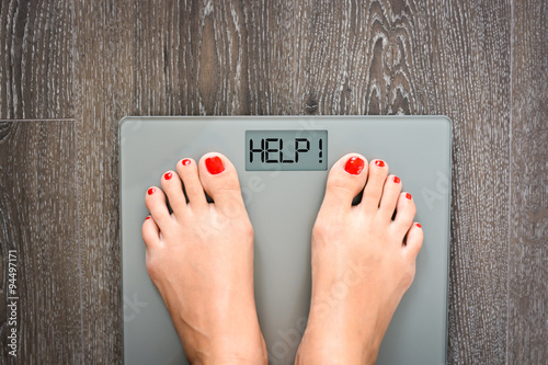 Fotomural Lose weight concept with person on a scale measuring kilograms