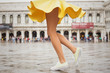 Leinwandbild Motiv Cheerful young woman wearing sneakers and yellow skirt