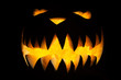 Spooky Halloween pumpkin with fangs and fire inside
