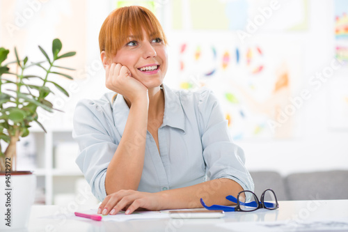 Professional beautiful young woman sitting her desk at her home Poster