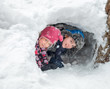© Dmitry Naumov - Happy boy and girl looking out from a snow cave they made in a snowdrift