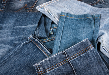 Canvas Print - fashionable clothes. pile of jeans on a wooden background