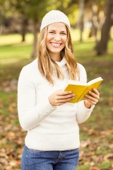 Wall Mural - Portrait of a smiling pretty woman reading a book