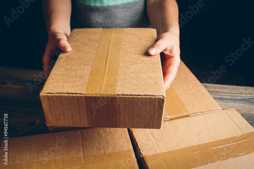 Cuadros en Lienzo Girl's hands holding the package on the table