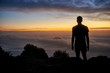 © marvent - Silhouette of a man on a mountain with a  cloudy sunrise