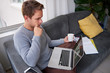 © marvent - Man on his couch with his laptop and a cup of coffee