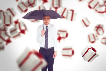 Poster - Composite image of businessman standing under black umbrella