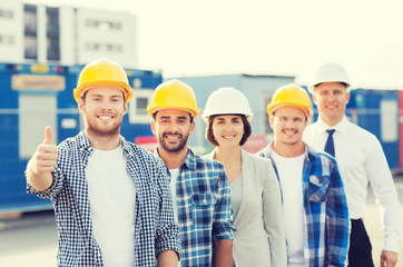 Wall Mural - group of smiling builders in hardhats outdoors