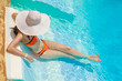 © timonko - Woman in big whire hat relaxing on the swimming pool