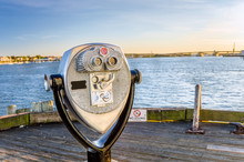 Coin-operated Binoculars On A Wooden Jetty At Sunset