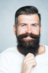 Grey-haired man pulling beard