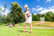 © Kzenon - Senior Frau beim Golf macht Abschlag