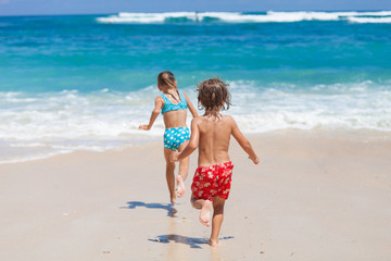 Canvas Print - Sister and brother playing on the beach at the day time.