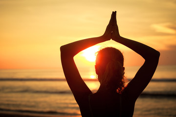 Wall Mural - woman open arms under the sunset at sea