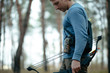 © antgor - Cropped man with hunter bow goes through the forest