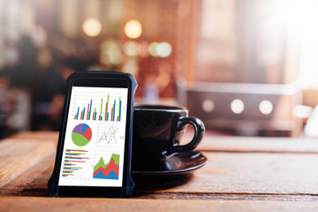 Poster - A Mobile phone showing stock market data on screen with coffee c