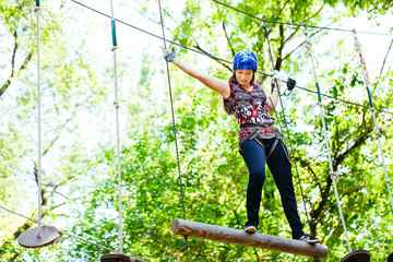 Adventure climbing high wire park - woman on course in mountain