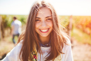 smiling teenage girl outdoors on sunny day. closeup of cute brunette young woman wearing casual clot