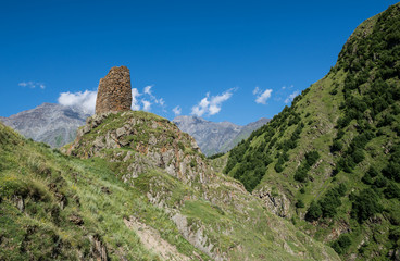 old fortified tower on the way from Stepantsmida town to Gergeti Trinity Church, Greater Caucasus Range in Georgia