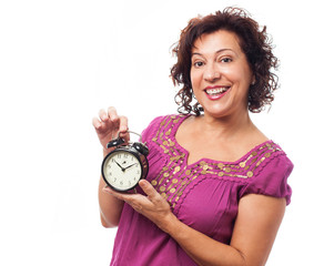 portrait of a mature woman holding an alarm clock on a white background